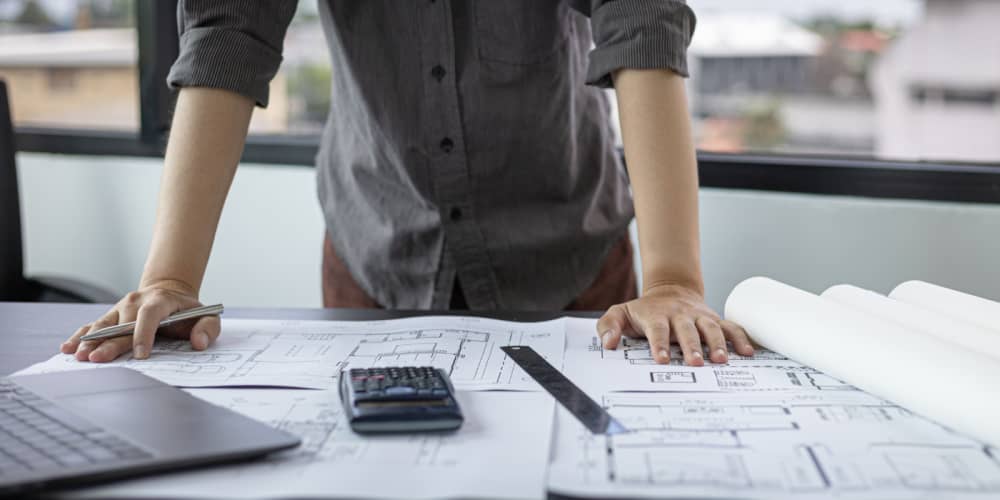 Construction architect looking at design plans on at the project job site